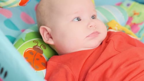 Happy Infant Lying in Colorful Playpen Close Up