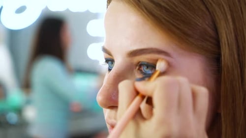 Woman Receiving Professional Eyebrow Makeup Application