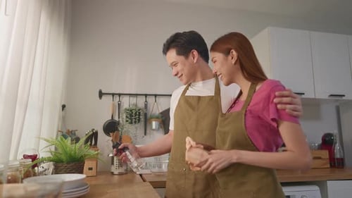 Happy Couple Cleaning Together in a Bright Kitchen