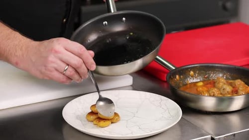 Chef Plating Fried Potatoes in Commercial Kitchen