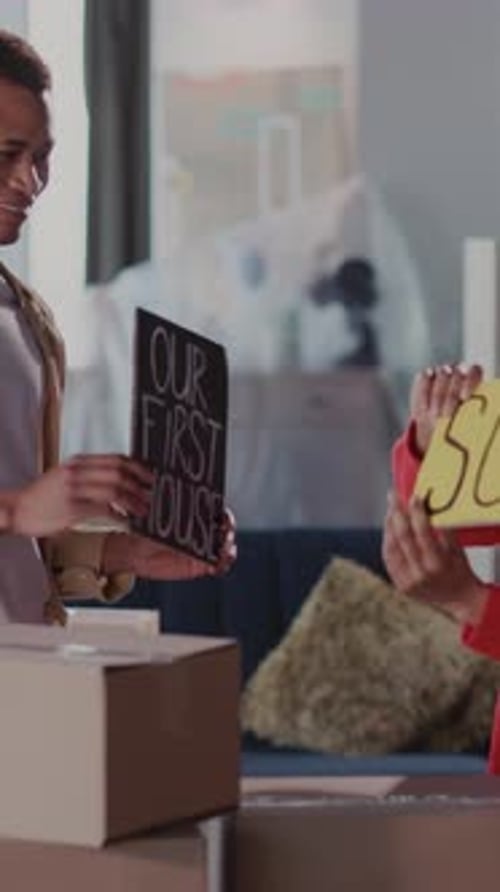 Couple celebrate buying their first home with signs