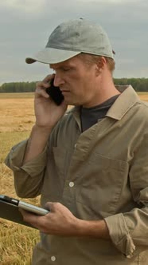 Farmer using Devices in Wheat Field