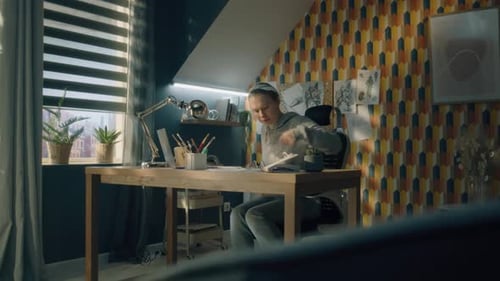 A Young Woman Sits on Her Work Desk in a Home Office and Draws a Pencil Sketch