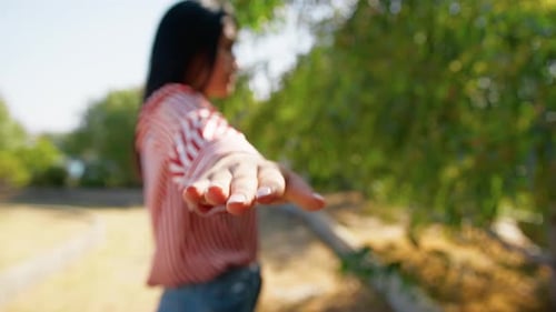 Woman Extending Hand in Green Nature Setting