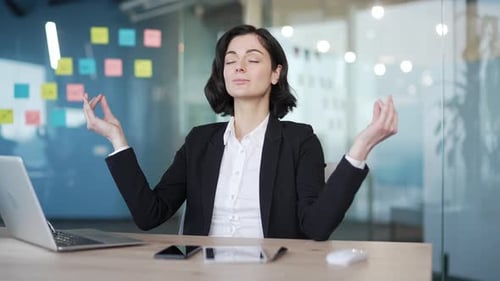 Businesswoman Meditating at Her Office Desk