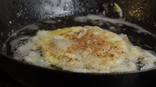 close-up view: Tasty egg sizzles and bubbles in hot butter frying pan