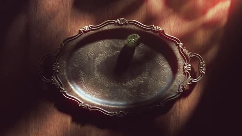 Green Easter egg spinning on a vintage silver tray.