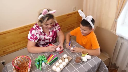 13Mother and son celebrate Easter. They prepare a basket, paint eggs and have fun.