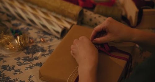 Hands Tying a Bow on Christmas Present