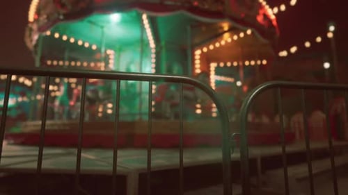 Empty Amusement Park at Night Featuring a Silent Carousel and Dim Lights