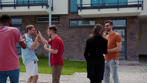 Friends capturing memories with mobile phones outside building