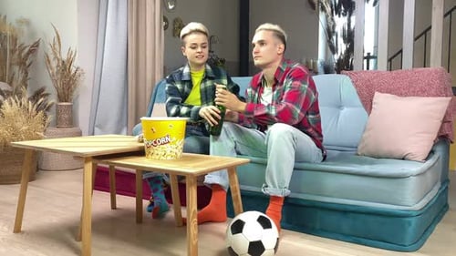 Young Adults Enjoy Watching Soccer Together at Home