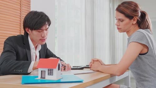 Young woman customer talking with agent about contract buy house and agreement of mortgage estate.