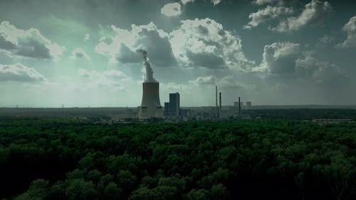 Aerial view of a coal power plant surrounded by lush green forests
