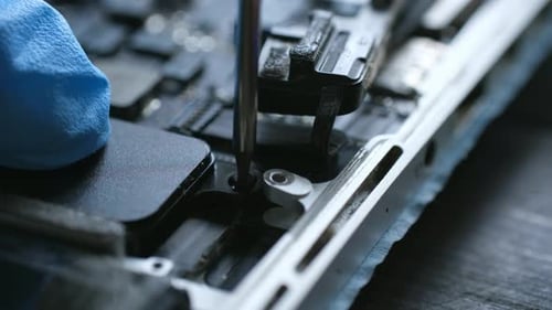 Close-Up of Gloved Hand Repairing a Computer