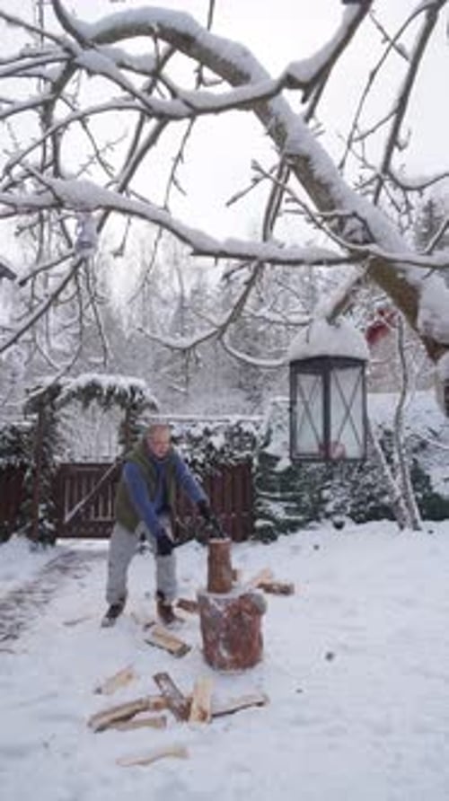 A Middleaged Man is Chopping Firewood