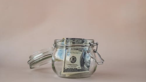 Stop Motion of Dollar Banknote Saving Money in Glass Jar Consumption and Economy Collecting Money