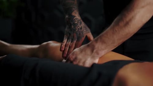 Therapist Giving Leg Massage in Dimly Lit Room