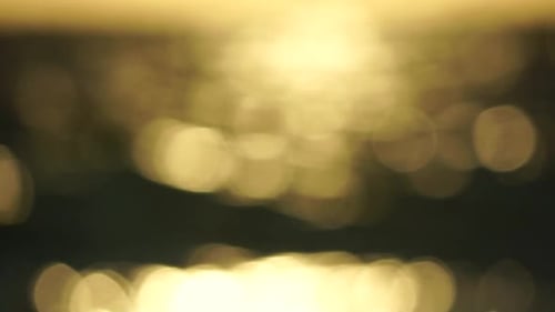 Blurred Golden Sea at Sunset The Sun Reflects and Sparkles on the Waves with Bokeh Illuminating the