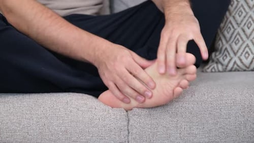 Adult Massaging Foot on the Couch