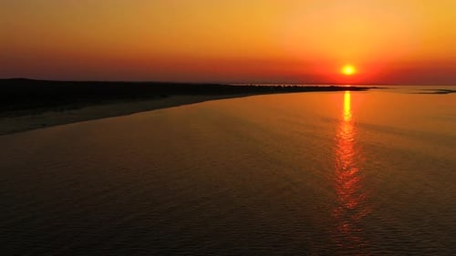 4K UHD Aerial drone view Beautiful sunset over tropical beach with clouds In the middle of the sea