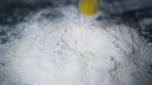 Close Up Slow Motion Video of Egg Falling Into Flour