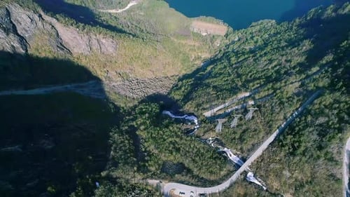 Vista aérea de uma montanha coberta de árvores verdes e um lago nas proximidades