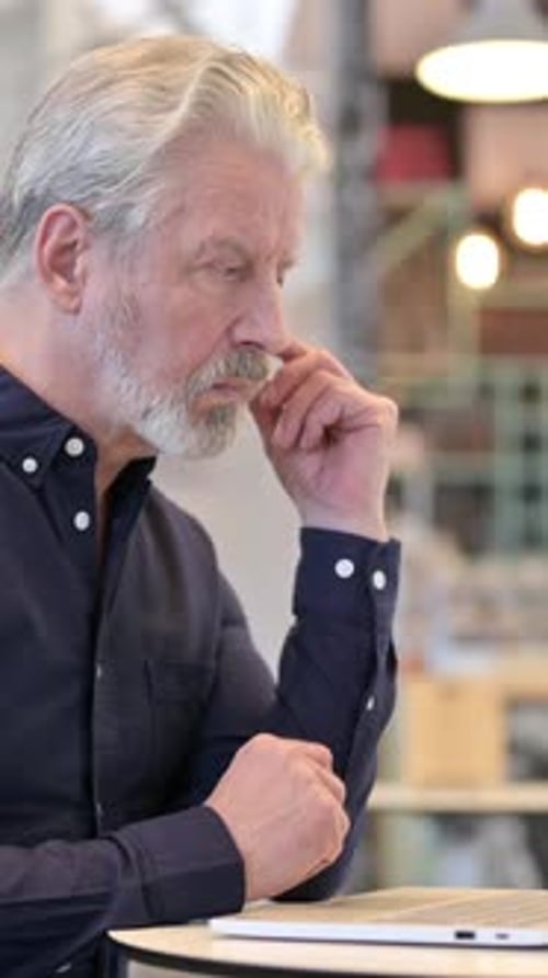 Pensive Old Man Using Laptop in Cafe, vertical video