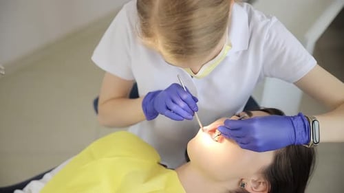 Dentist Using Hand to Examine Teeth Ears in Dental Office