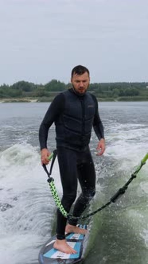 A Passionate Surfer Perfecting His Technique on a Choppy Water Surface Capturing the Thrill of