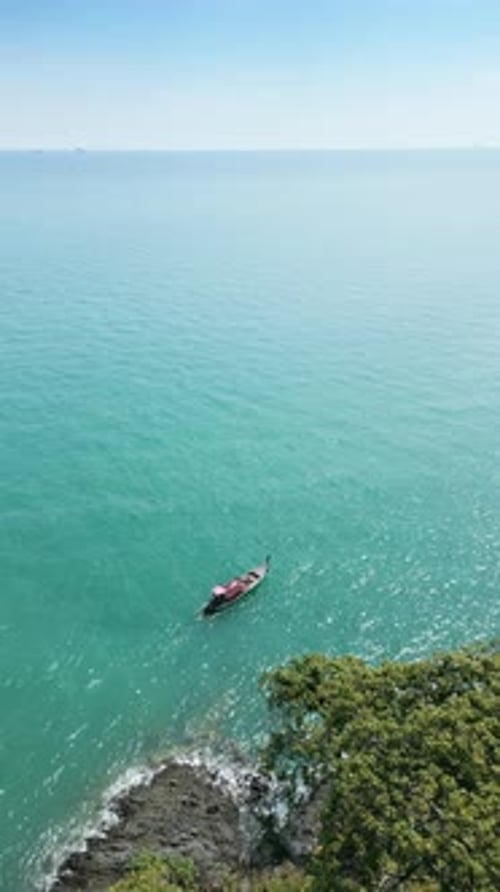 Boat Sails Along Tropical Island Coastline