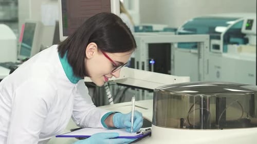 Woman Scientist Writing in a Bright Laboratory
