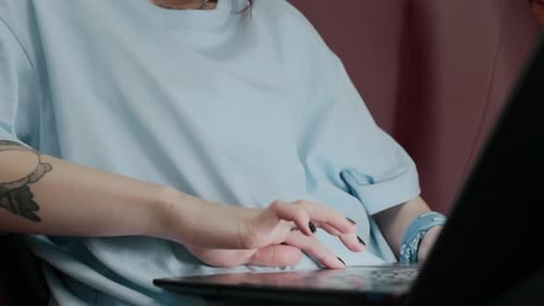 Young Adult Typing on a Laptop Indoors