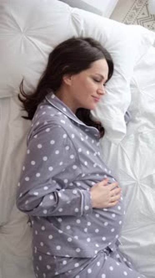 Pregnant Woman Relaxing in Bed at Home