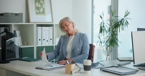 Mature woman, documents and review at office with budget, report or proposal at investment company