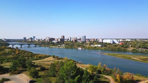 Daytime drone view of Saskatoon downtown, bridges, river, cars, and people