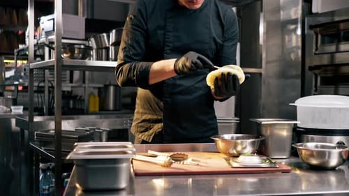 Chef Spreads Sauce on Bread in Restaurant Kitchen