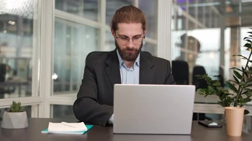 Stylish Creative Designer Typing Business Plan on Laptop in Office Interior