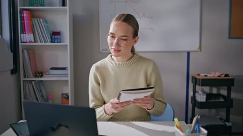 Young Woman Holding Notebook in Classroom Setting