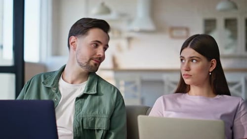 Young Couple Using Laptops on Sofa at Home