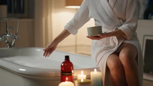 Woman Adds Salts to Relaxing Candlelit Bubble Bath