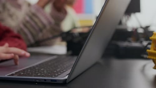 Students Learn Robotics Coding with Laptops in Classroom