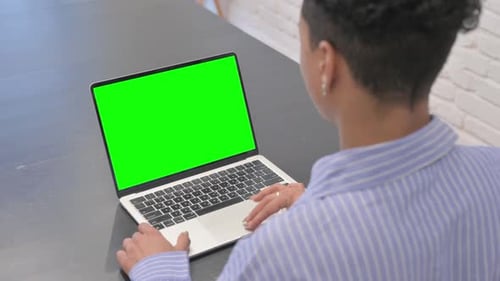 African Woman Using Laptop with Chroma Key Screen