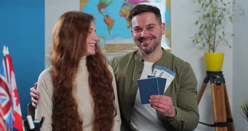 Happy Couple Holding Passports and Airline Tickets