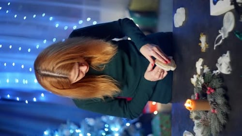 Woman smooths white ornaments in festive room