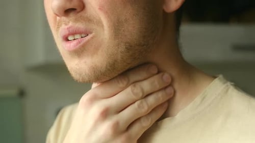 Adult Man with Sore Throat Holding His Neck