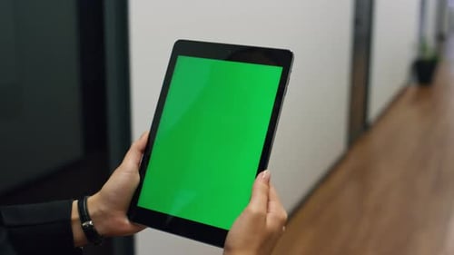 Corporate manager holding chroma key tablet watching online conference video