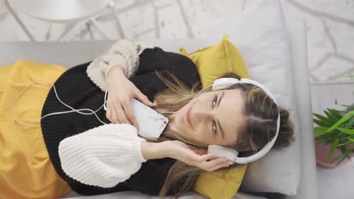 Woman Relaxing on Couch Listening to Music