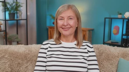 Smiling woman sitting on sofa in cozy living room