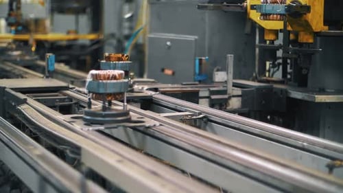 Metalldetail mit Kupferdraht, der sich im Werk auf einem automatischen Förderband bewegt.
Produktion